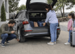 Familie care pregătește automobilul și bagajele pentru o călătorie în Grecia cu mașina