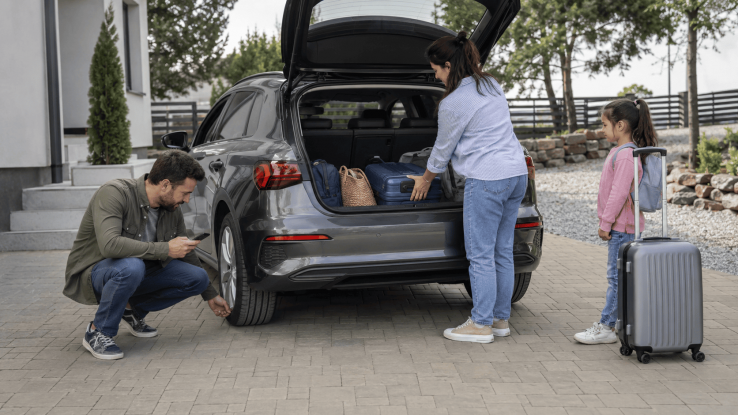 Familie care pregătește automobilul și bagajele pentru o călătorie în Grecia cu mașina